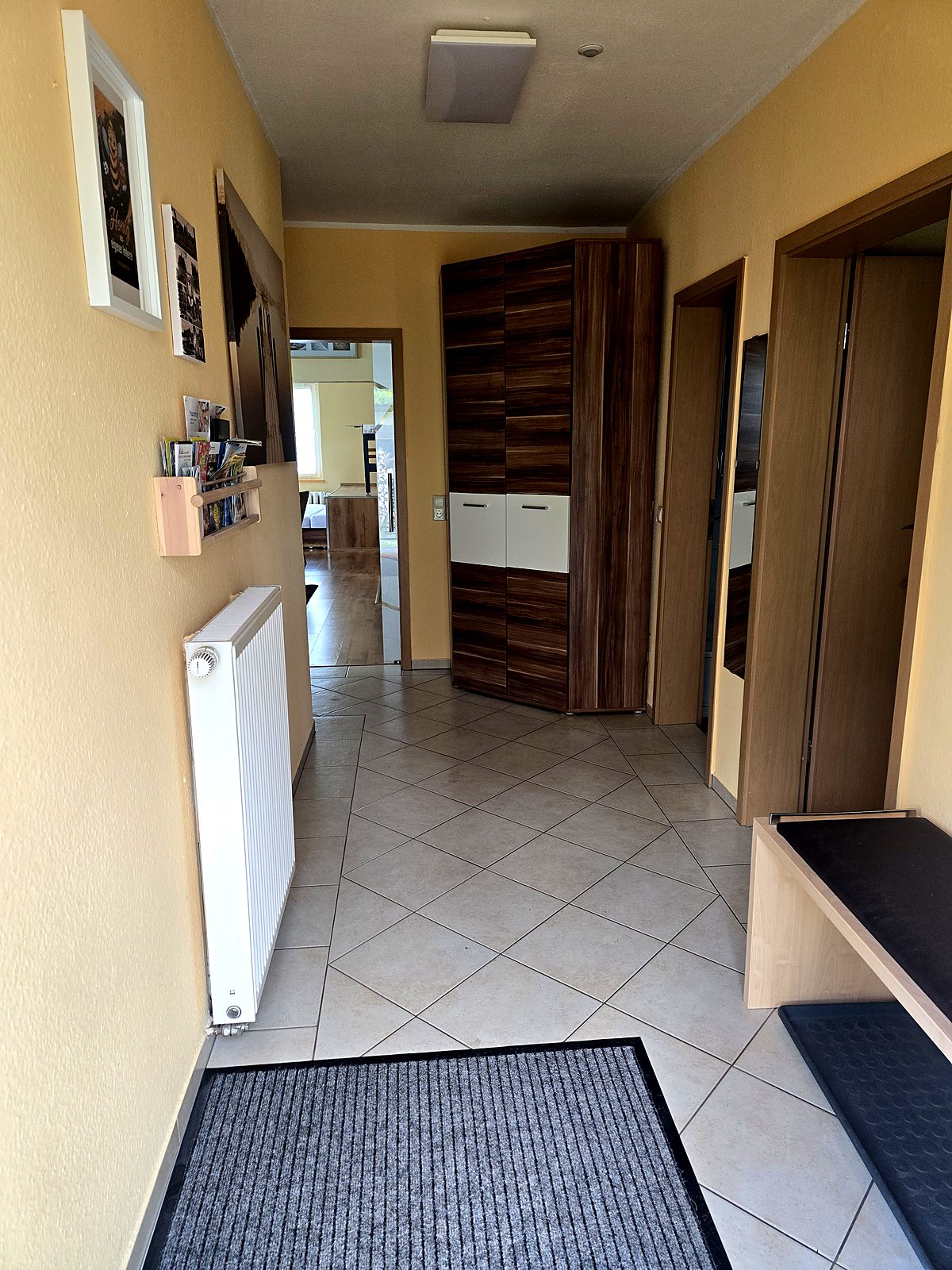 Heller Flur mit Garderobenschrank, Spiegel und Fliesenboden