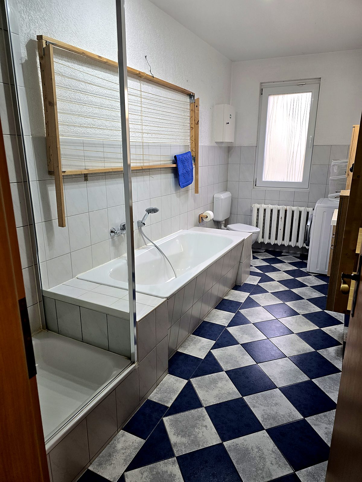Badewanne mit Handbrause und Fenster im Badezimmer