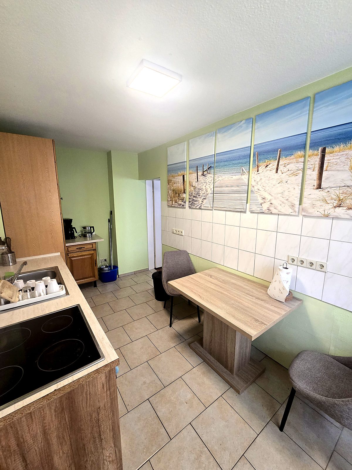 Küche mit Essplatz und Strandbildern an der Wand