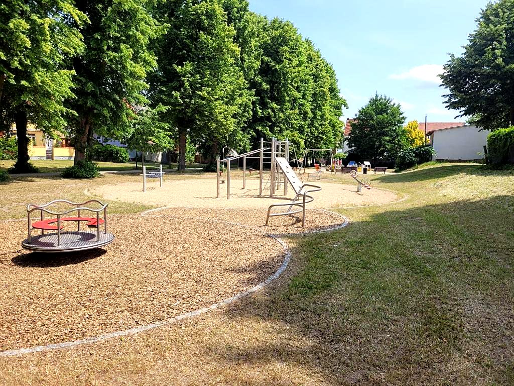 Spielplatz mit Karussell und Klettergeräten in unmittelbarer Nähe
