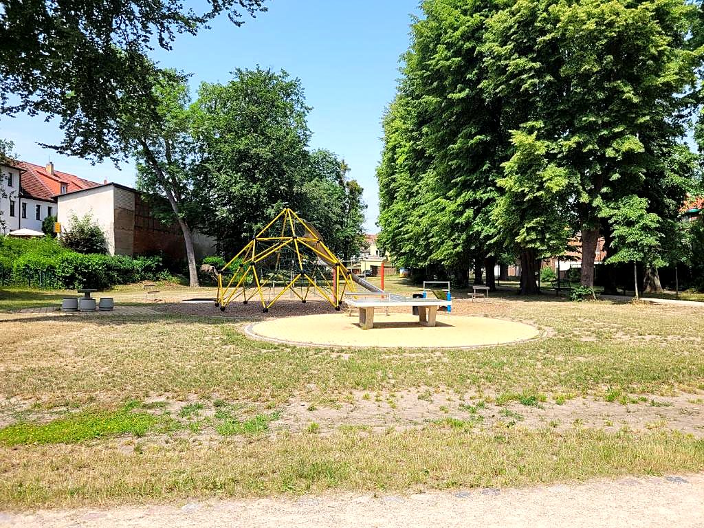 Grüner Park mit Klettergerüst und Tischtennisplatte