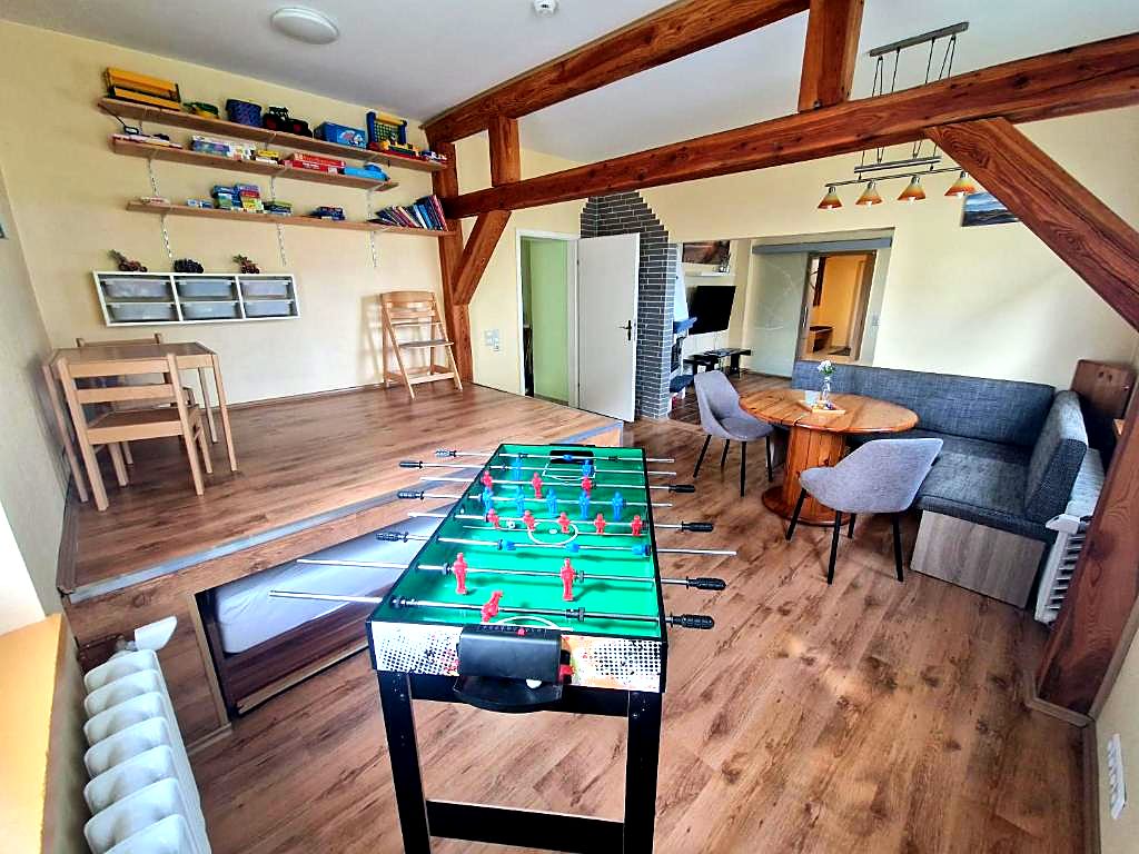 Spielbereich mit Tischkicker, Spieleregal und Sitzecke